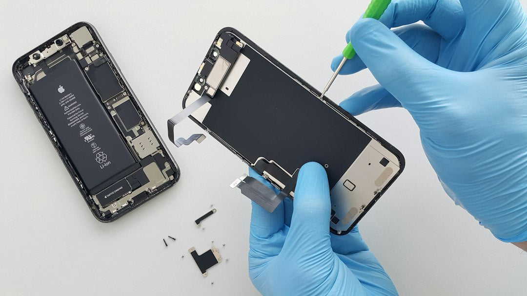 Technicien retirant la batterie d'un iPhone ouvert
