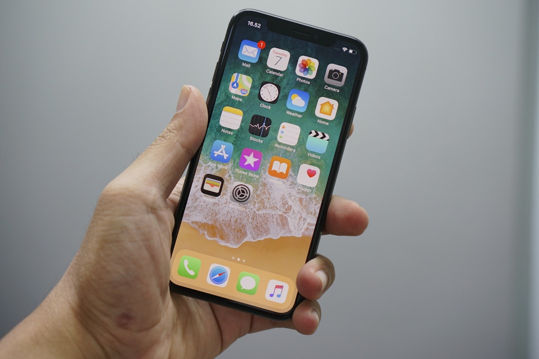 iPhone tenu en main affichant son écran d'accueil
