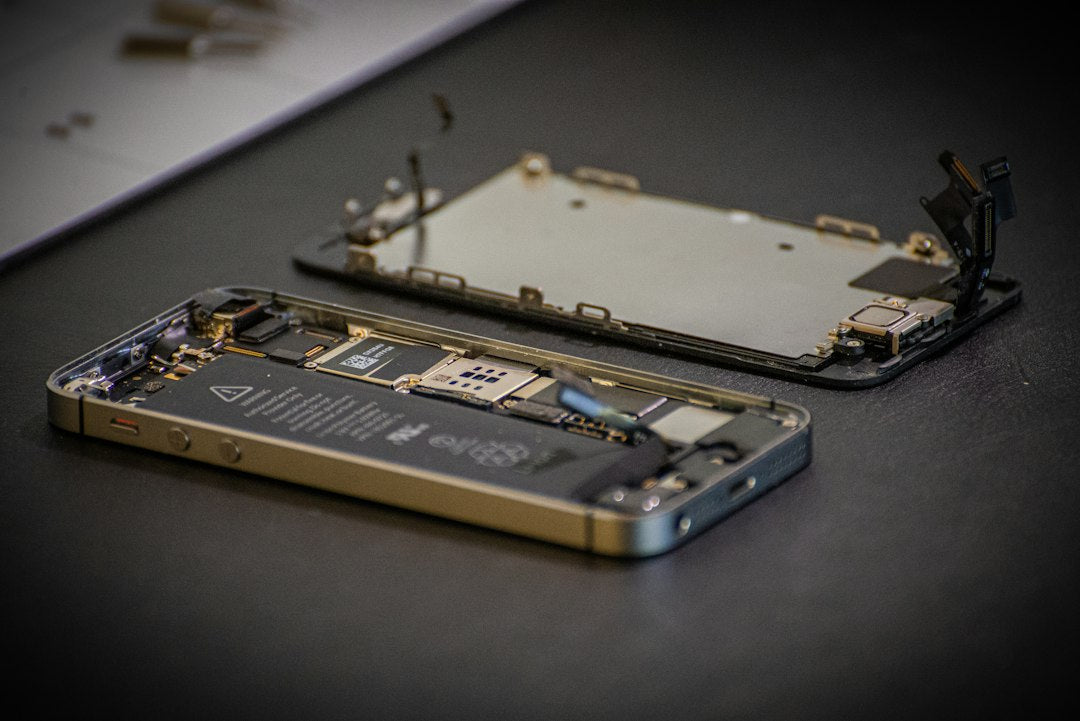 iPhone ouvert exposant sa carte mère en atelier de réparation